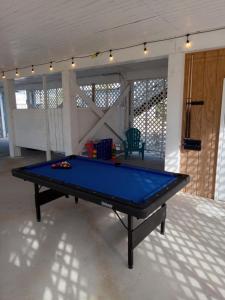 a large blue ping pong table in a room at Gulf Shores Haven Pools Tent Tiki Bar Games Pool Table Early Checkin in Gulf Shores