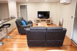 a living room with two chairs and a television at Come dine with me at Jo in Baldivis