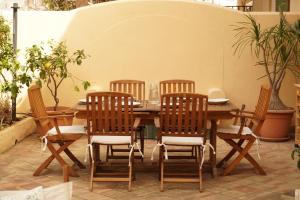 einen Holztisch und Stühle rund um einen Tisch in der Unterkunft Casa Al Mare Sole e Relax in San Vito lo Capo + 30 Fotos