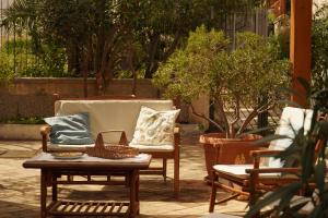 eine Terrasse mit zwei Stühlen und einem Tisch mit Kissen in der Unterkunft Casa Al Mare Sole e Relax in San Vito lo Capo