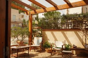 eine Terrasse mit Stühlen, einem Tisch und einer Pergola in der Unterkunft Casa Al Mare Sole e Relax in San Vito lo Capo