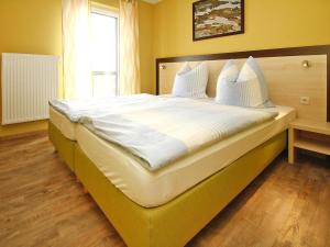 a large bed with white sheets and pillows in a bedroom at Apartment in Plau am See mit Terrasse in Plau am See