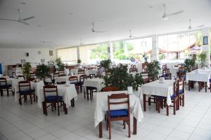 a dining room with white tables and chairs at Karbel Beach Hotel in Oludeniz