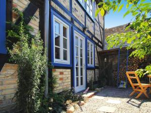 una casa con finestre blu e bianche e una sedia di Ferienwohnung, Plau am See a Plau am See Altre 2 foto