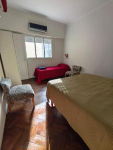 ein Schlafzimmer mit einem Bett und zwei Stühlen und einem Tisch in der Unterkunft Ciudad de Buenos Aires - próximo a la Recoleta Teatro Colón Obelisco - Apartamento ideal para parejas y familias C in Buenos Aires