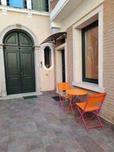 two chairs and a table in front of a door at Palazzo Penzo Bellemo in Chioggia