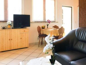 ein Wohnzimmer mit einem Sofa und einem Tisch mit einem TV in der Unterkunft Bungalow by Lake Kummerow with Private Beach in Sommersdorf
