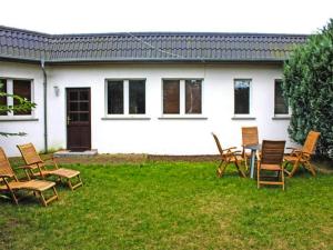 eine Gruppe von Stühlen und einem Tisch vor einem Haus in der Unterkunft Bungalow by Lake Kummerow with Private Beach in Sommersdorf