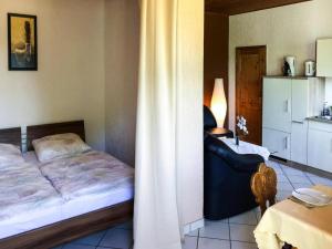 ein Schlafzimmer mit einem Bett, einem Stuhl und einem Tisch in der Unterkunft Bungalow by Lake Kummerow with Private Beach in Sommersdorf
