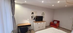 a bedroom with a bed and a desk with a television at Maris Apartment in Târgu-Mureş