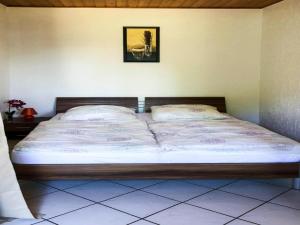ein Bett in einem Schlafzimmer mit einem Bild an der Wand in der Unterkunft Bungalow by Lake Kummerow with Private Beach in Sommersdorf
