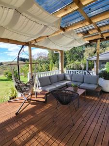 a patio with a couch and a hammock and an umbrella at Gem on Bastia Hill in Whanganui