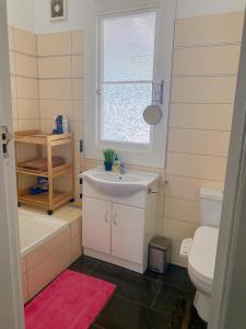 a bathroom with a sink and a toilet and a window at Gem on Bastia Hill in Whanganui +50 photos