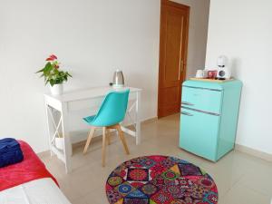 a room with a desk and a blue refrigerator at Habitación Estepona Rainbow in Estepona