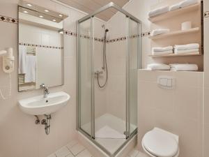 a bathroom with a shower and a toilet and a sink at Ferien- und Freizeitpark Weissenhäuser Strand in Weissenhäuser Strand +24 photos