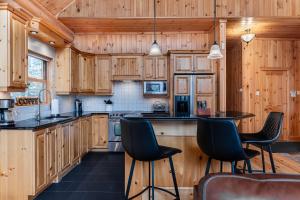a kitchen with wooden cabinets and black counter tops at Fiddler Lake Resort - Deer 76 in Mille-Isles +21 photos