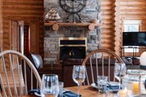 a dining room with a table and a fireplace at Fiddler Lake Resort Chalet 76 Deer in Mille-Isles +21 photos