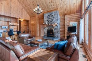 a living room with leather furniture and a fireplace at Fiddler Lake Resort - Deer 76 in Mille-Isles