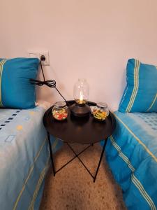 a small table with two beds and a candle on it at El Rinconcito Mágico in El Bosque +40 photos