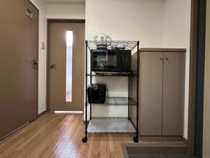 a room with a microwave on a shelf with a microwave at Harenohi hakushima in Hiroshima +57 photos