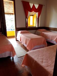 a room with three beds and a window at Quarto com varanda em casa próxima a área hospitalar em BH in Belo Horizonte