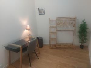 a room with a desk with a chair and a plant at Chambre confortable et indépendante - Proche aéroport, Lyon et la Plaine de l'Ain in Saint-Jean-de Niost