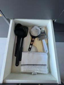 a white drawer filled with cooking utensils in a kitchen at Studio TEC Centro de convenções Smart Home in Salvador