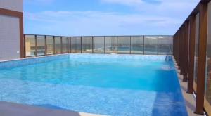 a large swimming pool with blue water in a building at Studio TEC Centro de convenções Smart Home in Salvador