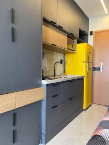 a kitchen with gray cabinets and a yellow refrigerator at Studio TEC Centro de convenções Smart Home in Salvador