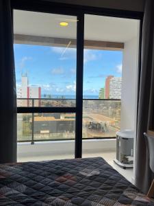 a bedroom with a large window with a view of a city at Studio TEC Centro de convenções Smart Home in Salvador +29 photos