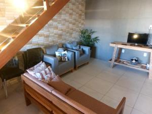 a living room with a couch and a tv at Casa Mar in Passo de Camarajibe