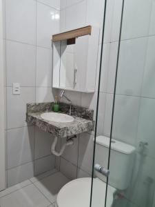 a bathroom with a sink and a toilet at Hospedagem Aracê in Domingos Martins