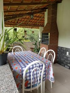 a table and four chairs on a patio with a table and a brick at Hospedagem Aracê in Domingos Martins