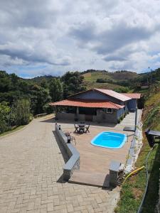 a house with a patio and a swimming pool at Hospedagem Aracê in Domingos Martins