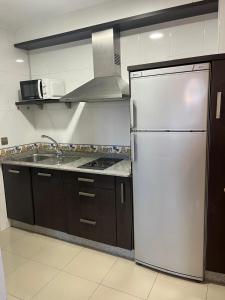 a kitchen with a white refrigerator and a sink at Caldas no Camiño in Caldas de Reis +7 photos