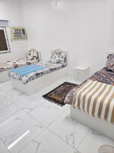 a white room with two beds and a tv at Welcome Ten 5km far from Masjid Nabawi in Al Madinah