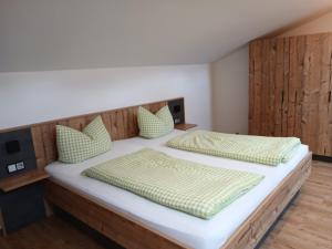 1 dormitorio con 2 camas individuales y almohadas verdes en Gästehaus Hillebrand, en Bischofswiesen