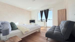 Un dormitorio con una cama, un sofá y una silla. en Komfort Apartment Neumünster Ideal für Firmen & Langzeitaufenthalte, en Neumünster