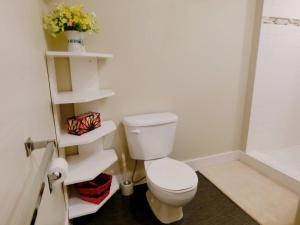 a bathroom with a toilet and white shelves at Love Capilano in North Vancouver