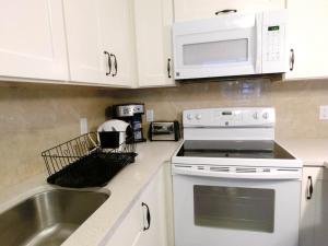 a kitchen with a sink and a stove and microwave at Love Capilano in North Vancouver +4 photos