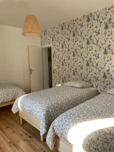 una camera con due letti e una parete a motivi geometrici di Lili-Belle, maison de vacances a Livinhac-le-Haut