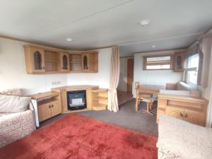 a living room with a couch and a table and a desk at J25 Kirbys Retreat 3, Skegness in Winthorpe