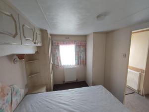 a small bedroom with a bed and a window at J25 Kirbys Retreat 3, Skegness in Winthorpe