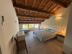 ein Schlafzimmer mit einem Bett und einem Stuhl in einem Zimmer in der Unterkunft Sunset INN in Scardovari