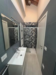 ein Badezimmer mit weißem Waschbecken und Dusche in der Unterkunft Sunset INN in Scardovari