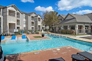 a swimming pool in a yard with houses at Houston Lakeside Living in Houston