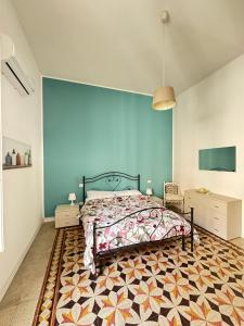 a bedroom with a bed and a blue wall at sole e mare nel cuore di R C in Reggio Calabria