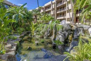 a garden with a waterfall in front of a building at Awesome Paki Maui Beach condos in Lahaina in Lahaina