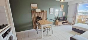 a living room with a table and a bedroom at Le Cœur des Océanes in Pornichet