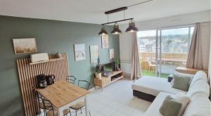 a living room with a couch and a table at Le Cœur des Océanes in Pornichet